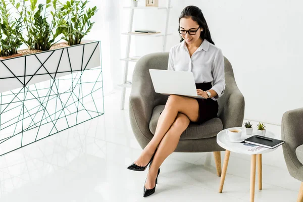 Bela Sorrindo Asiático Empresária Óculos Sentado Poltrona Usando Laptop Escritório — Fotografia de Stock