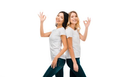 sırt sırta duran ve üzerinde beyaz izole ok işaret gösteren mutlu genç kadın