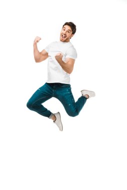 excited young man jumping and smiling at camera isolated on white clipart