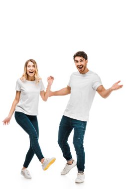 happy young couple in white t-shirts dancing and smiling at camera isolated on white clipart