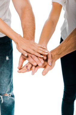 close-up partial view of young friends stacking hands isolated on white