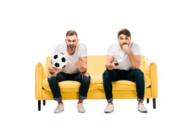 duygusal genç erkekler futbol ile kanepede oturan ve üzerinde izole beyaz maç spor tarassut top