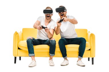 excited young men in virtual reality headsets playing with joysticks isolated on white 