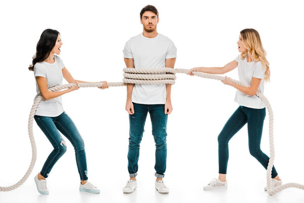 emotional young women holding rope around young man isolated on white  