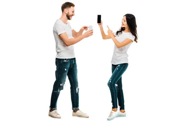 Happy Young Couple Showing Each Other Smartphones Isolated White — Stock Photo, Image