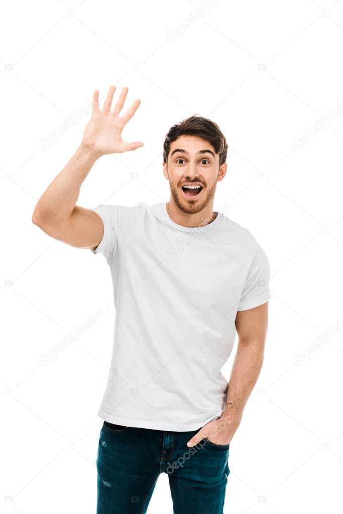 cheerful young man waving hand and smiling at camera isolated on white