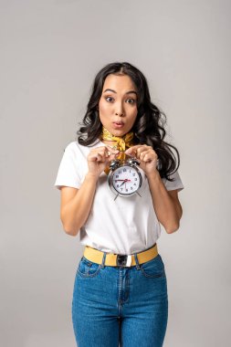 Çalar saat kendini gri izole önünde tutan sürpriz Genç Asyalı kadın 
