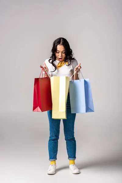 Sorprendido Joven Asiático Mujer Mirando Dentro Colorido Compras Bolsas Gris — Foto de Stock