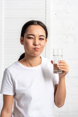 Genç Asyalı kadın beyaz t-shirt durulama ağız su ile 