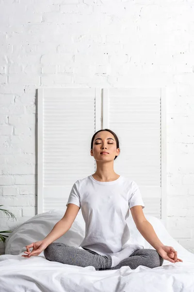 Asiatin Weißem Shirt Und Grauer Leggings Sitzt Lotus Pose Bett — Stockfoto