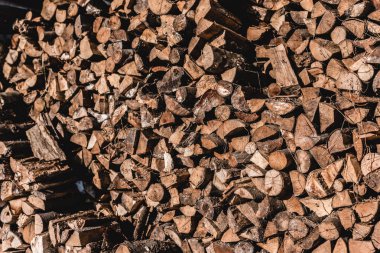 pile of brown cut firewood at sunny day  clipart