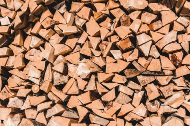 pile of brown cut textured firewood at sunny day  clipart