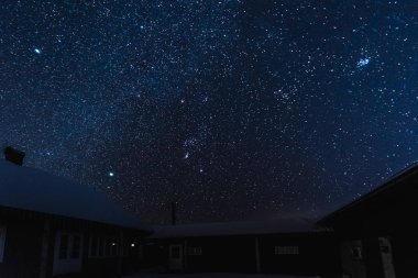 yıldızlı karanlık gökyüzü ve kışın geceleri karla kaplı evleri