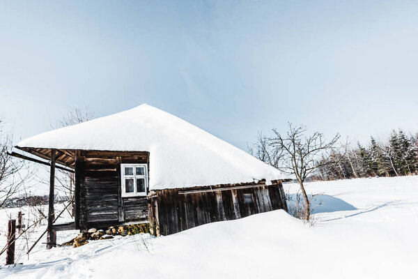 old wooden house with snow in winter carpathian mountains