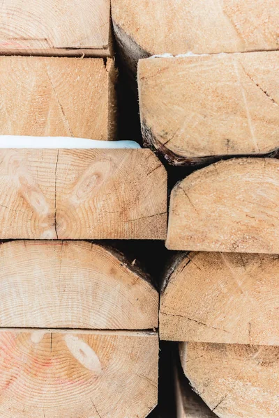 棕色的木木原木堆叠在桩和覆盖着雪 — 图库照片