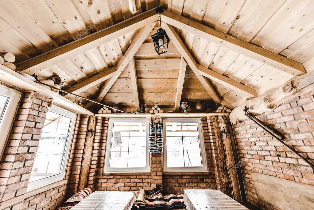 Interior of wooden rural cottage with windows and brick walls