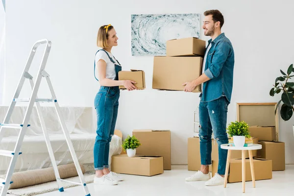 Visão Completa Casal Sorrindo Segurando Caixas Papelão Olhando Uns Para — Fotografia de Stock