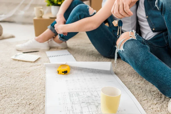 Cropped View Couple Sitting Carpet Blueprint Keys Measuring Tape — Stock Photo, Image