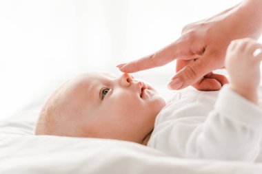 yatak odasında bebek hafifçe dokunan anne kırpılmış görünümü