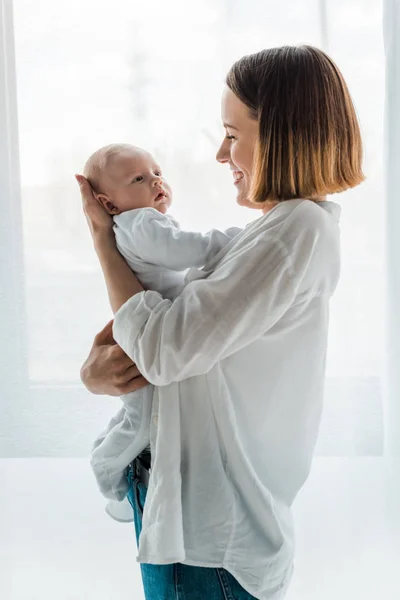 Madre Sonriente Camisa Blanca Sosteniendo Bebé Casa —  Fotos de Stock