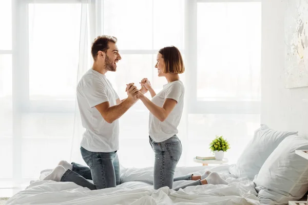 Happy Couple Holding Hands Looking Each Other Bedroom — Stock Photo, Image