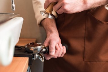 Zemin kahve ve kurcalamak ile portafilter tutan barista kısmi görünümü