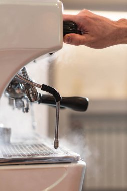 Cropped view of barista using coffee machine in cafe clipart
