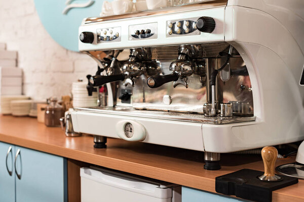 Современная кофеварка на деревянной поверхности в кафе
