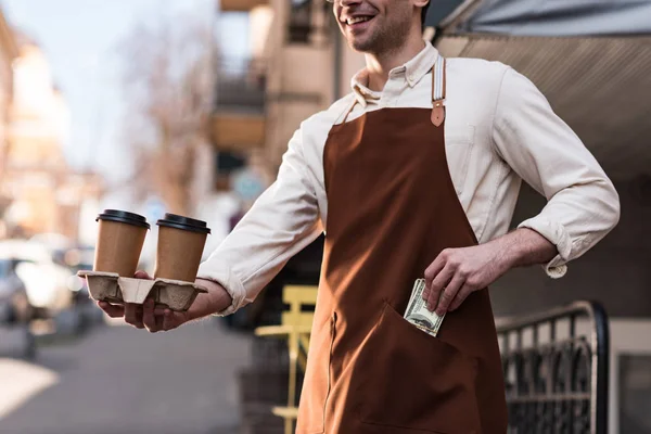 Vista Recortada Barista Sosteniendo Tazas Papel Café Poniendo Dinero Bolsillo — Foto de Stock