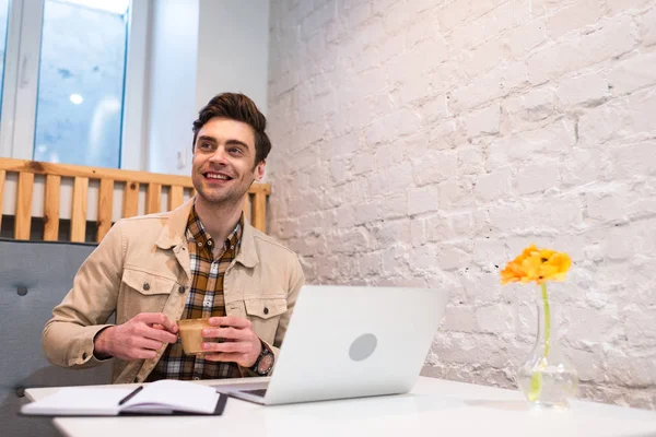 Freelancer Sonriente Con Portátil Sosteniendo Taza Café Cafetería — Foto de Stock