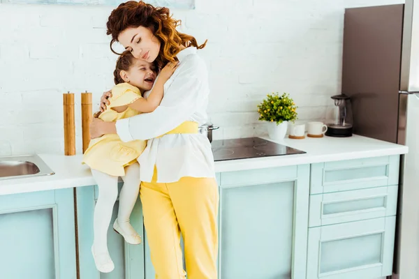 Ευτυχισμένη Μητέρα Αγκαλιάζοντας Ενθουσιασμένη Κόρη Στην Κουζίνα — Φωτογραφία Αρχείου