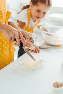 kızının yanında bıçakla tereyağı kesme anne seçici odak