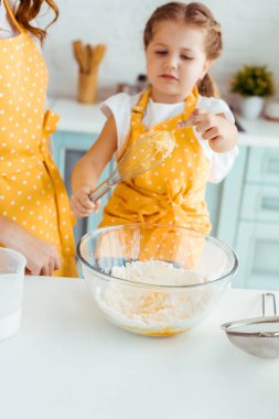 sarı polka nokta önlük kızının seçici odak hamur ile balon çırpMa bakarak