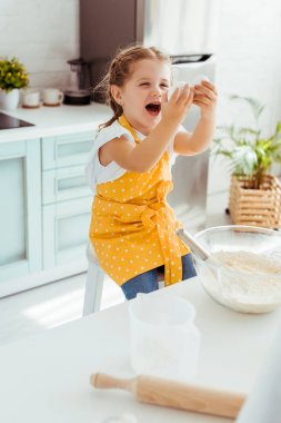 mutfakta hamur pişirirken yumurta bakarak sarı polka nokta önlük heyecanlı çocuk 