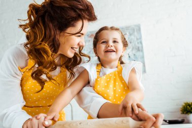 birlikte ahşap oklava tutan heyecanlı kızı ile mutlu anne