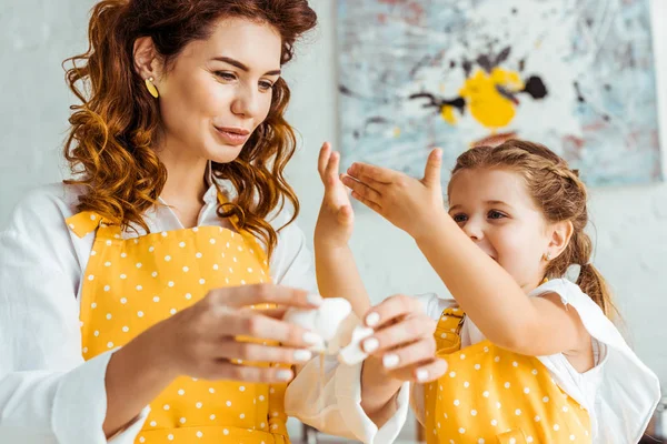 Foco Seletivo Mãe Segurando Casca Ovo Enquanto Filha Gesticulando Cozinha — Fotografia de Stock