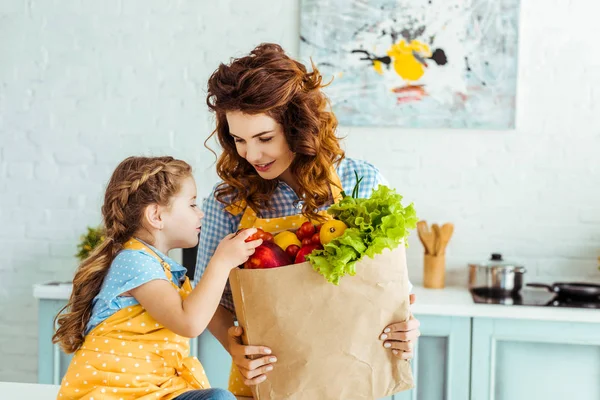 과일과 야채와 호기심 가방을 보여주는 행복한 어머니 — 스톡 사진