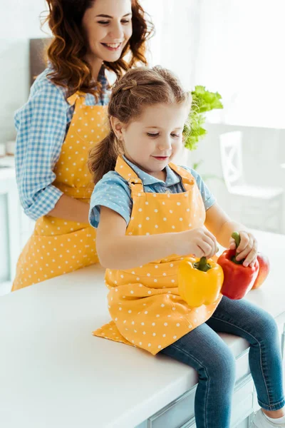 Smiling Daughter Polka Dot Apron Holding Colorful Bell Peppers Happy — Stock Photo, Image