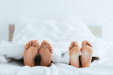 yatakta yatan yalınayak ile erkek ve kadın kırpılmış görünümü 