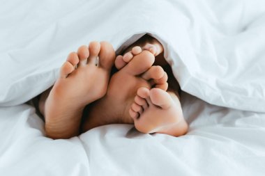 yatakta yatan yalınayak ile kız arkadaşı ve erkek arkadaşı kırpılmış görünümü 