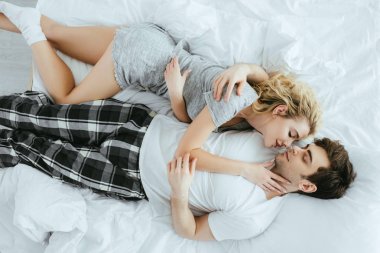 yatakta yatarken sarılan mutlu çift üst görünümü 
