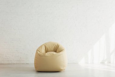 modern evde tuğla duvara yakın fasulye çanta sandalye yakınında güneş ışığı 
