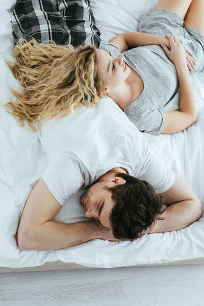 金发女子躺在床上与男人的头顶视图 — 图库照片