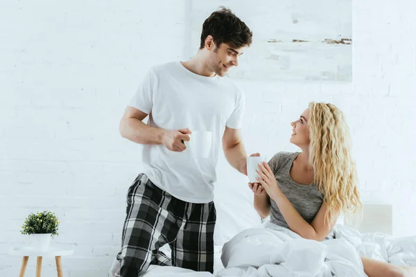 Homem Alegre Dando Copo Para Menina Loira Feliz Casa — Fotografia de Stock