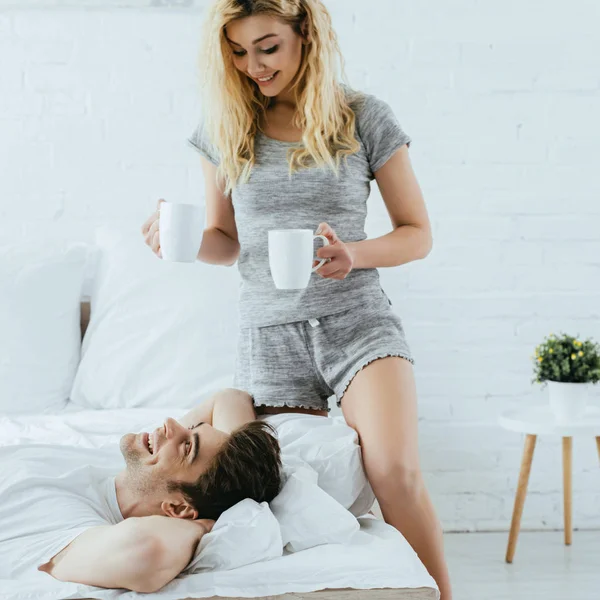 Alegre Rubia Chica Celebración Tazas Con Café Cerca Feliz Hombre — Foto de Stock