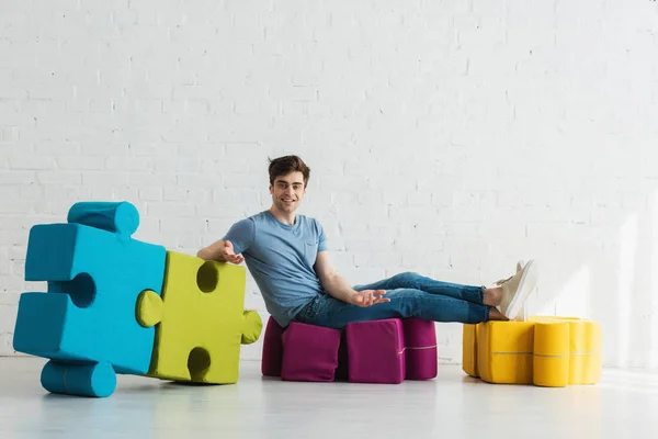 Cheerful Man Looking Camera Connected Blue Green Jigsaw Pieces While — Stock Photo, Image