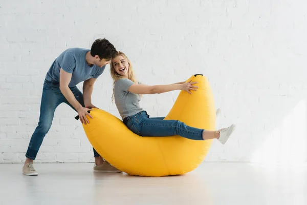 Cheerful Woman Sitting Yellow Bean Bag Chair Looking Handsome Man — Stock Photo, Image