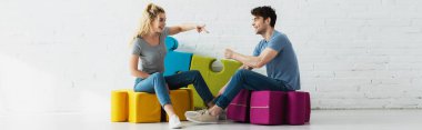panoramic shot of cheerful blonde girl and handsome man playing rock paper scissors game  clipart