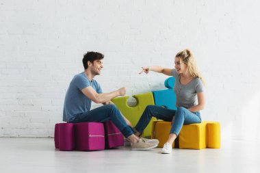 cheerful blonde girl and handsome man playing rock paper scissors game  clipart