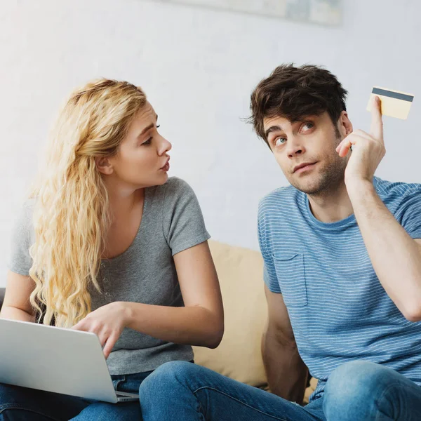 Mulher Loira Atraente Usando Laptop Falando Com Homem Segurando Cartão — Fotografia de Stock